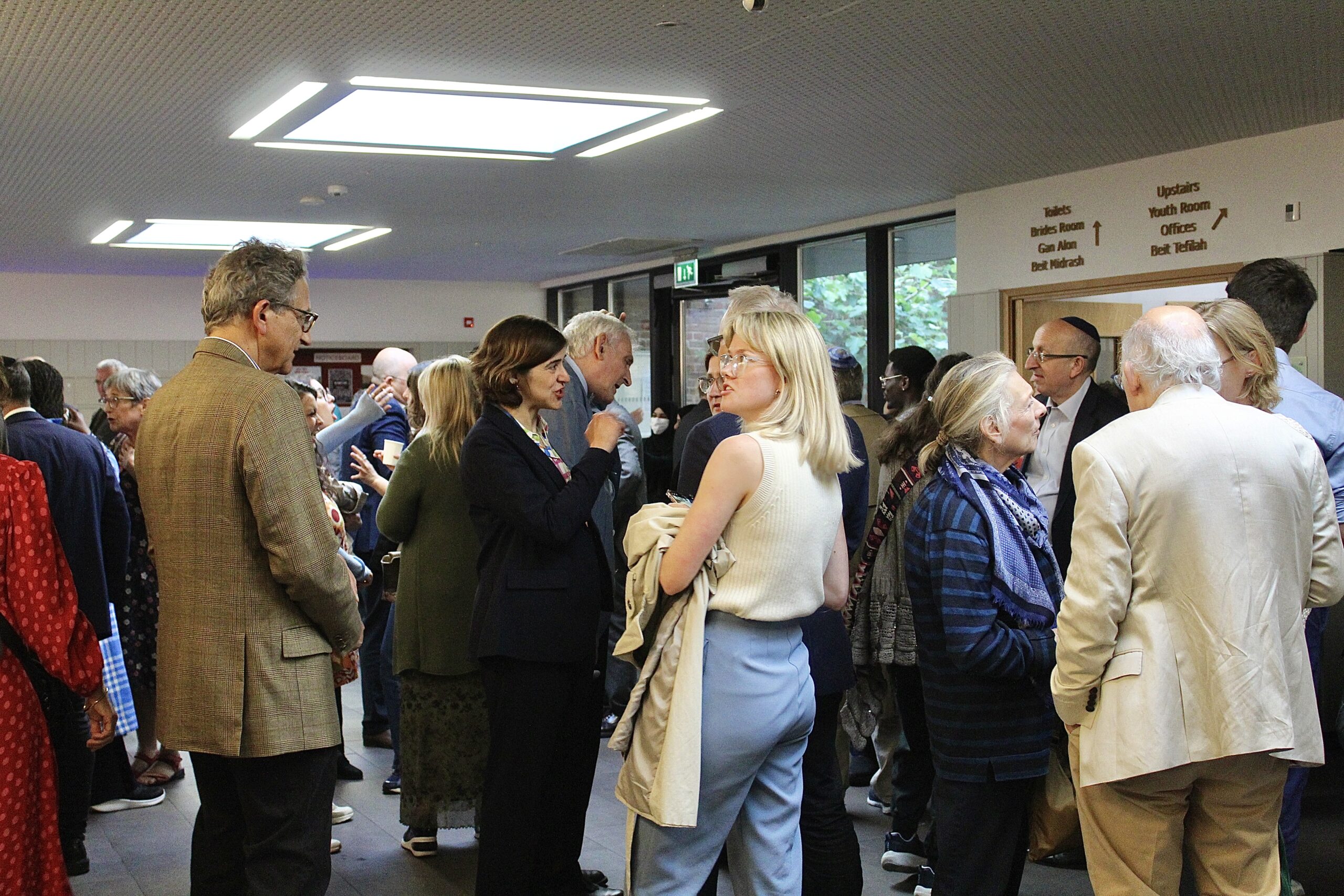 Image shows attendees chatting before at the event reception. The Labour MP Sarah Sackman can be seen in the centre of the photo.