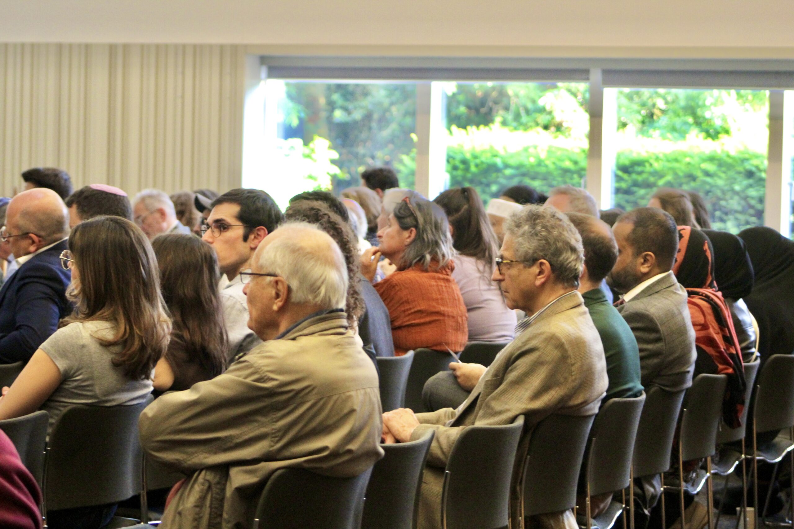 Image shows a side-on view of attendees sat down in rows at the HIAS+JCORE anniversary event.