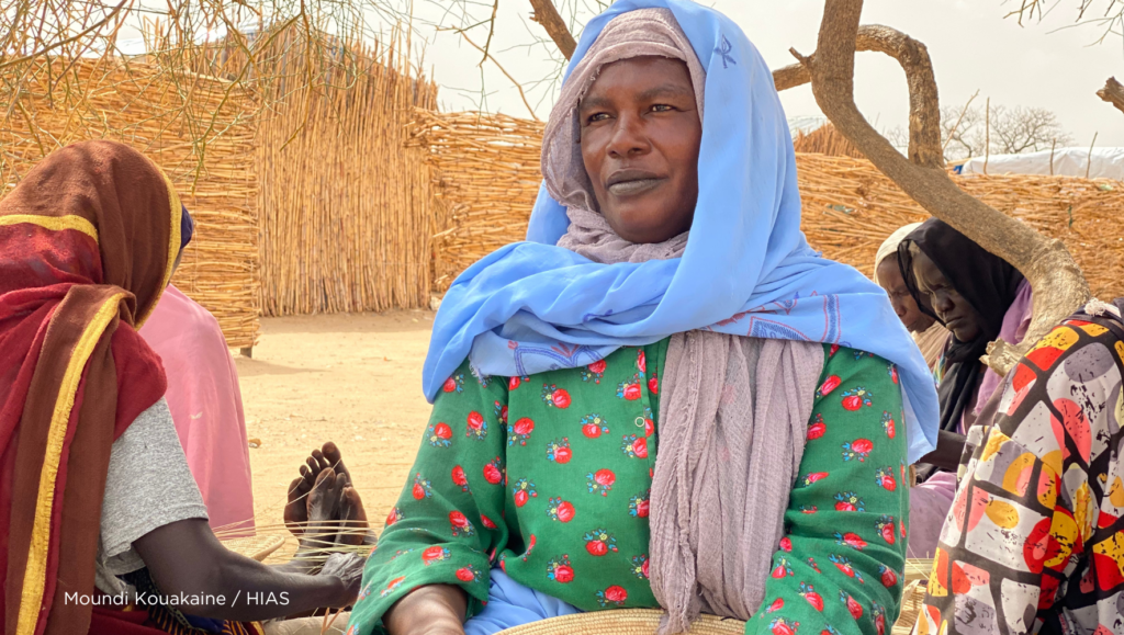 A woman sits down looking into the distance.