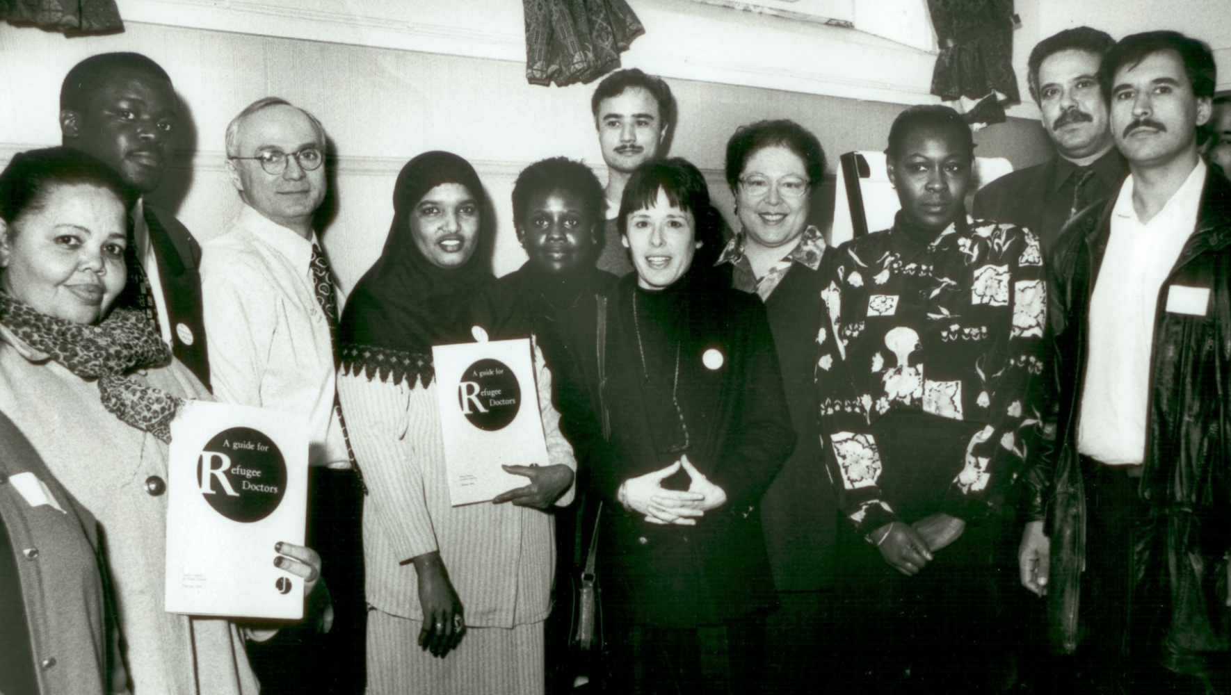 HIAS+JCORE's Honorary President, Dr Edie Friedman (centre, with hands folded), former Chair, Dr Richard Stone (third left), and early members of our Refugee Doctors project. 